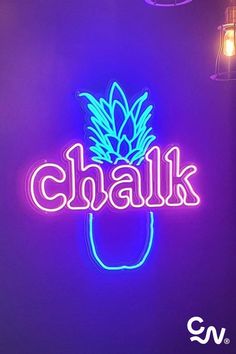 a neon sign that says chalk with a pineapple on it in front of a purple background