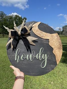 a hand holding up a sign that says hoddy on it in the grass