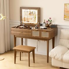 a dressing table with a mirror and stool in a living room next to a window