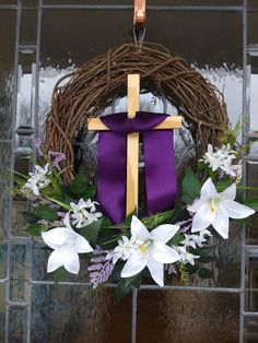 a wreath with flowers and a cross on it