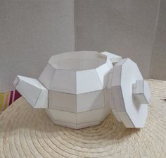 an origami teapot is sitting on a table