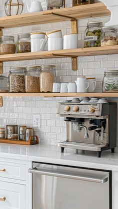 a kitchen with open shelving and coffee maker on the counter, surrounded by glass jars