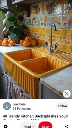 the kitchen sink is yellow and has oranges on it