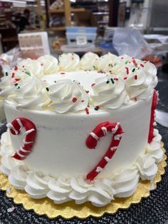 a white frosted cake with candy canes on top