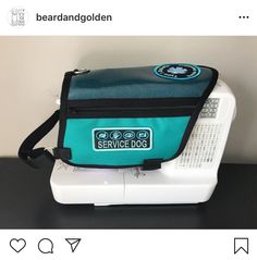 a blue and black bag sitting on top of a white table next to a sewing machine