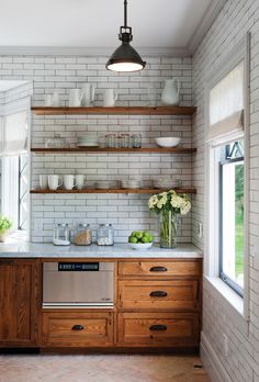 a kitchen with white brick walls and wooden cabinets