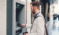 a man is using an atm machine in the city