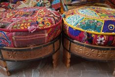 two wooden stools with colorful cushions on them