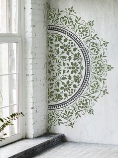 the wall is decorated with green and black designs on it, along with a window