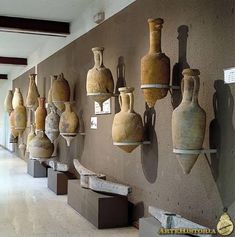 there are many vases hanging on the wall