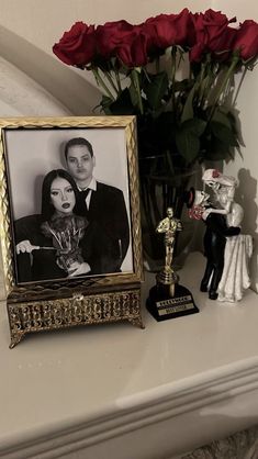 a couple is posing in front of a photo with a cat figurine next to it