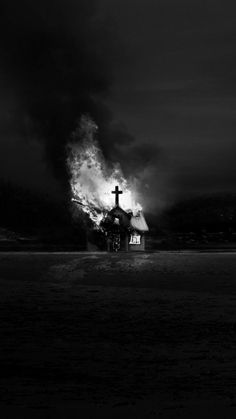 a black and white photo of a church on fire