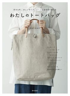 a woman is holding a bag in front of her face with japanese writing on it