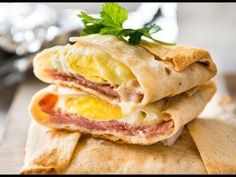 two burritos stacked on top of each other with an egg and ham in the middle