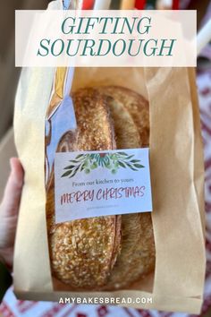 a person holding a baguette in their hand with the text, gifting sourdough merry christmas