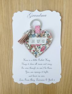 a heart shaped keychain with the words grandma on it and a pink ribbon