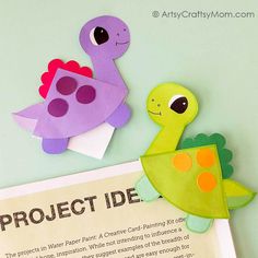 two paper dinosaurs are next to a project idea