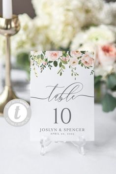 the table numbers are placed on top of each other, with flowers in the background