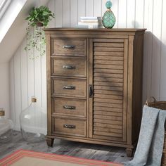 a chest of drawers in a room with a rug and potted plant on the floor