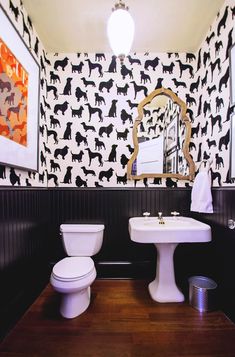 the bathroom is decorated with black and white wallpaper, including a dog pattern on the wall