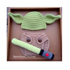 crocheted baby yoda and the child's hat are in a box