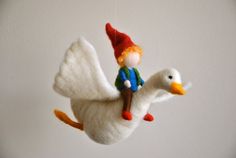 a small white bird with a gnome on it's back flying in the air