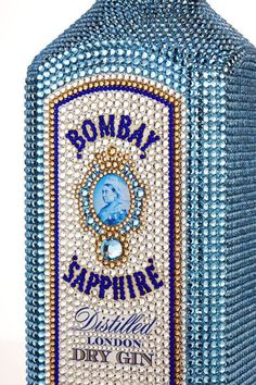 a blue bottle that has some beads on it's side and the words, bomb sapphire