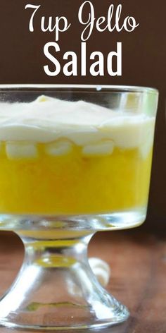 a glass bowl filled with yellow jello and topped with whipped cream in the middle