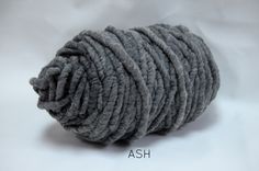 a ball of gray yarn sitting on top of a white table covered in water droplets