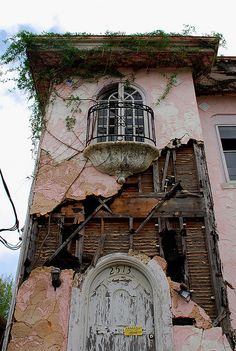 an old building with vines growing on it's side and a door in the middle