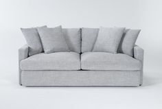 a gray couch with four pillows on it's back and one arm facing the camera