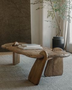 a wooden bench sitting in front of a window next to a vase with a plant