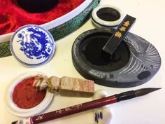 an assortment of chinese items including ink, brush and paperweights on a table