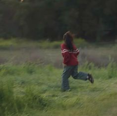 a person running through a field with a kite in the air