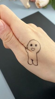 a person's hand with a small tattoo of a dog on the thumb and wrist