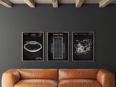 two framed football posters on the wall above a couch in a room with dark walls