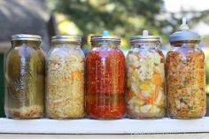 five jars filled with different types of food