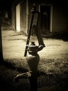 an old fire hydrant in front of a house with a ladder leaning on it