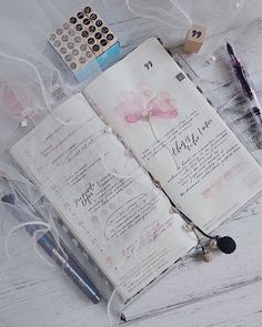 an open book with writing on it next to a pen and calculator