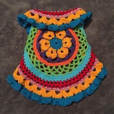 a crocheted multicolored pot holder on the floor