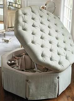 an upholstered white ottoman sits in front of a mirror