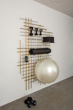 an exercise ball and gym equipment hanging on a wall in a room with white walls