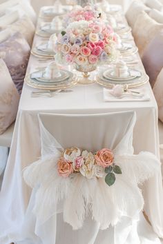 the table is decorated with flowers and feathers