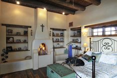 a dog laying on top of a bed in a bedroom next to a fire place