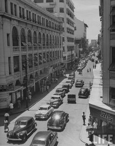 an old black and white photo of cars on a city street