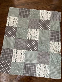 a patchwork quilt is laying on top of a wooden floor with polka dots and circles