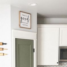 a kitchen with white cabinets and green door