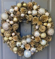 a christmas wreath is hanging on the front door with balls and pine cones around it