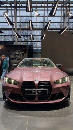 a pink sports car parked in front of a building