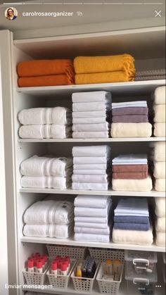 towels are stacked on shelves in the closet